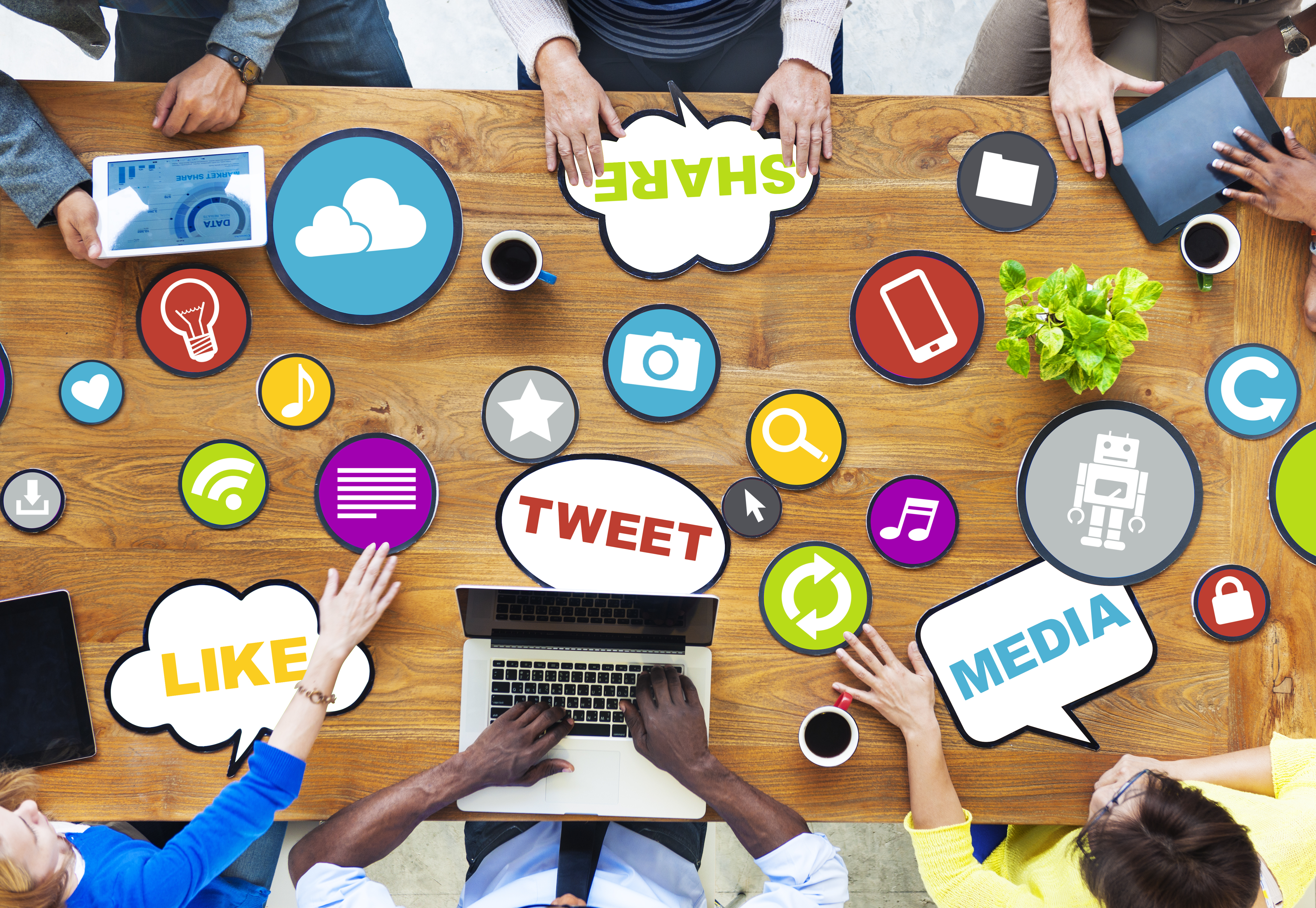 A stock image of people sitting at their desk onn their mobile devices.